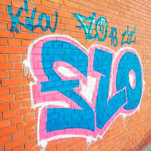 Enlevement de graffiti bleus sur un mur en brique